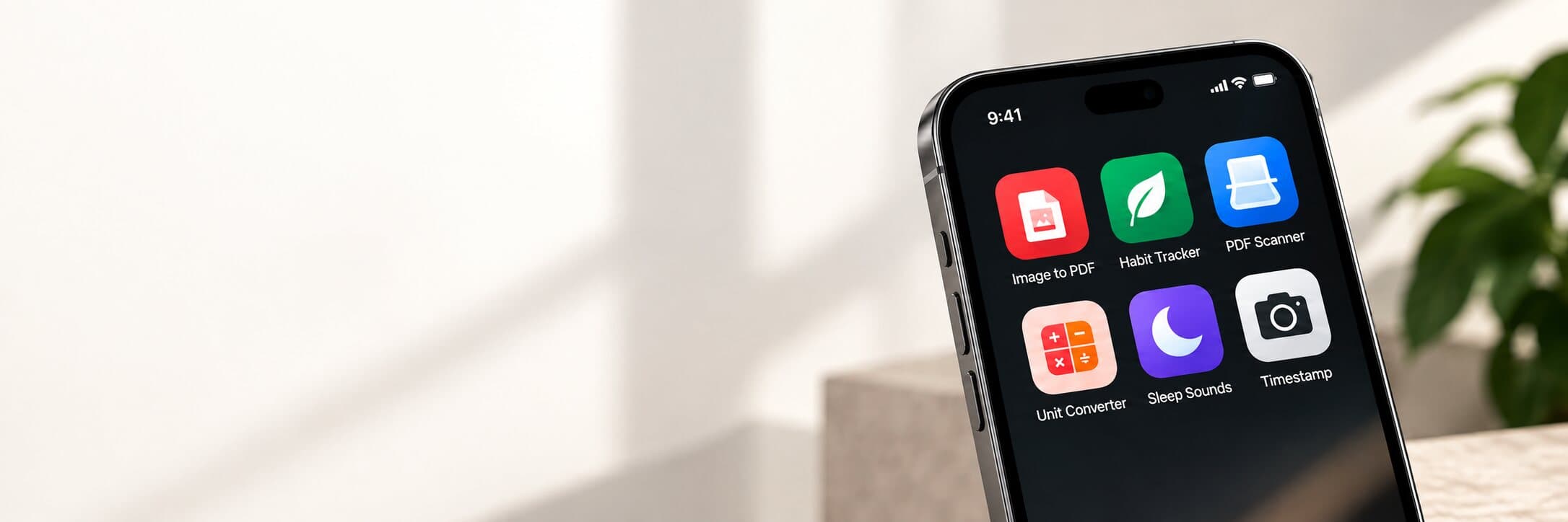 A large phone showing the Appalaxy app collection next to a blurred plant